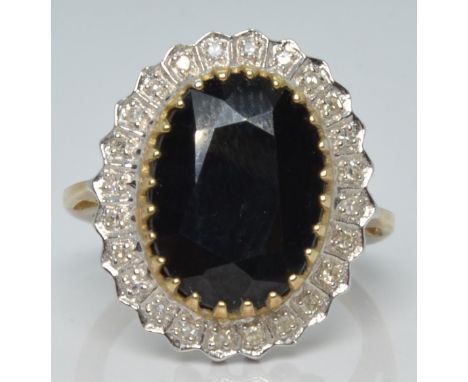 A 9ct gold ring set with a large oval sapphire surrounded by diamonds, 5.1g, size M/N