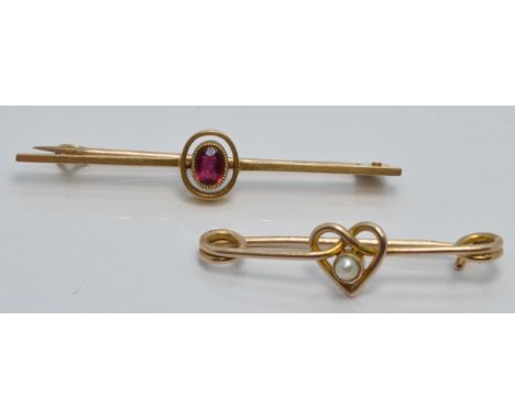 A 15ct gold brooch set with a ruby (2.4g) and a 9ct gold brooch set with a seed pearl in a heart setting (1.5g)