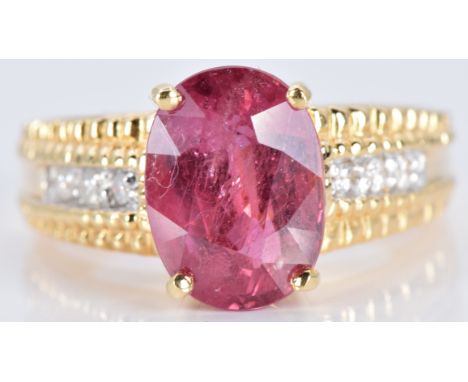 An 18ct gold ring set&nbsp;with an oval cut ruby and diamonds, 7.7g, size N