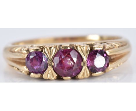 A 9ct gold ring set with three round cut garnets, 3.1g, size M