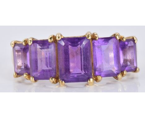 A 9ct gold ring set with emerald cut amethysts, 2.4g, size M