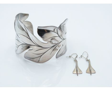 A white bangle in a foliate design (63g) and a pair of Concorde earrings