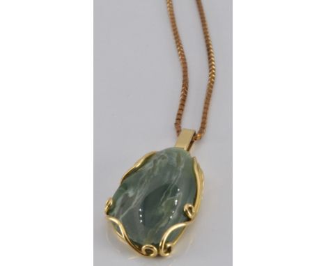 An 18ct gold pendant set with jade (5.1g) on a 9ct gold chain (4.0g)