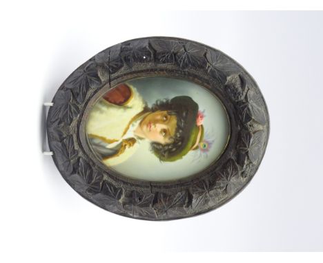 19th century Continental oval porcelain plaque hand painted with a half length portrait of a young Austrian boy wearing a gre