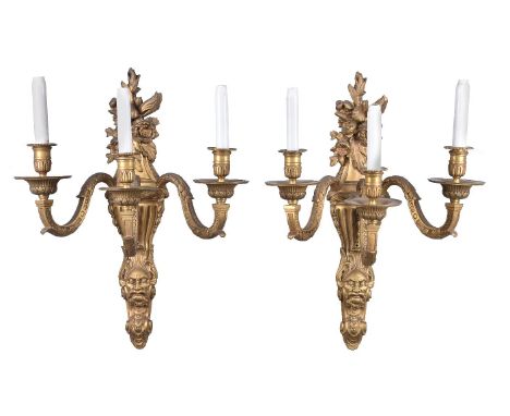 A set of eight gilt bronze three branch wall appliques in Régence taste, first quarter 20th century, the beaded and fluted sc
