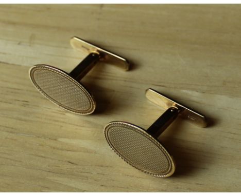 A pair of 9ct gold 'Swivlink' cuff-links, of traditional form with engine-turned decoration, 7 grams total. Good used conditi