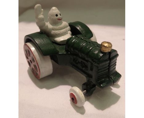 Cast iron Michelin man on a tractor, H: 8 cm. P&amp;P Group 1 (£14+VAT for the first lot and £1+VAT for subsequent lots) 
