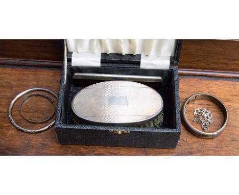 A cased silver backed gentlemen's hair brush and comb set, Birmingham 1924, together with three silver bangles and a white me