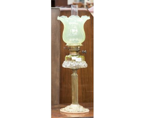 A late Victorian brass oil lamp with moulded green tinted glass reservoir/shade