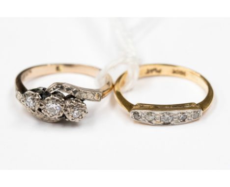 Two diamond set 18 ct gold rings: a diamond three stone illusion set crossover; and a diamond five stone boat head ring; appr