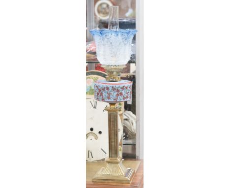 A late Victorian brass oil lamp with blue glass reservoir/shade