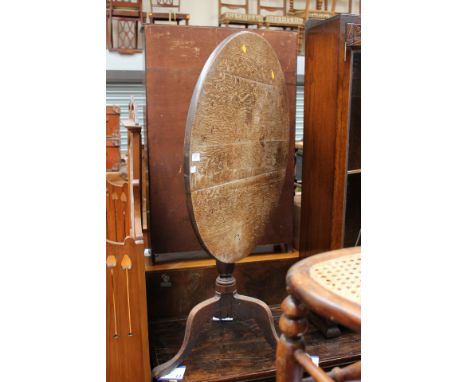 A George III oak tilt-top tripod table, the plank top raised on a turned column, raised on cabriole legs, 71 cm high, 78 cm d