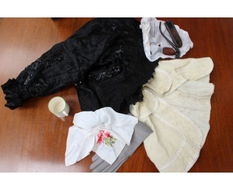 A black Edwardian mourning cape with lace trim and sequin detail, together with a child's cape in cream linen with couched co