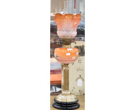 A late Victorian brass oil lamp with opaque orange glass reservoir/shade
