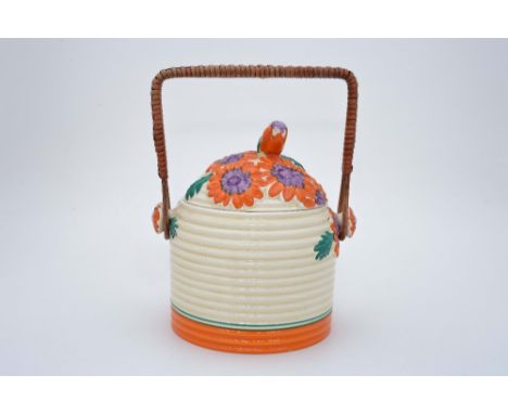 Clarice Cliff for Newport Pottery, an orange 'Marquersite' biscuit barrel, beehive form with rattan handle