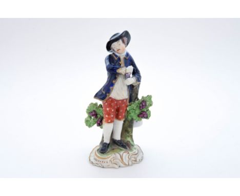 A Derby figure emblematic of Autumn, standing leaning on a tree stump wearing a cobalt blue coat and red pants, c.  1810, 13 