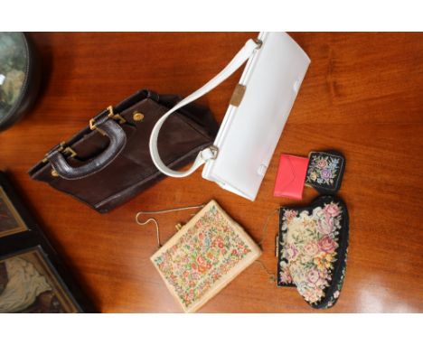 A collection of handbags to include a 1960s white patent and a black patent, a 1970s snakeskin bag with two handles, a navy c