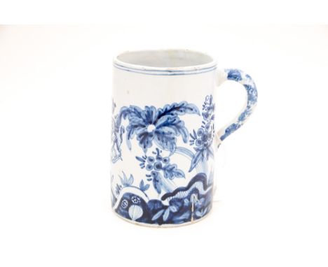 A blue and white tin glaze pottery mug, possibly 18th Century Delftware, the body hand painted depicting a crest surrounded b