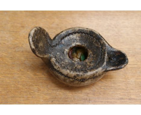 A ceramic oil lamp in Roman style.