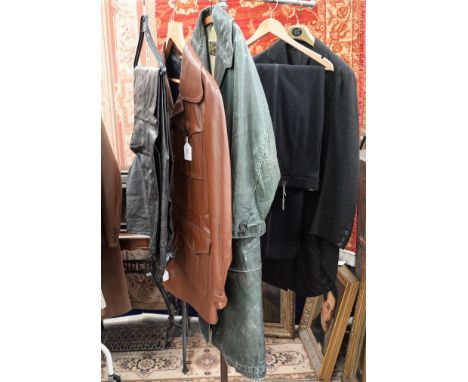 A black wool Edwardian tail coat and a pair of evening trousers  a tan leather jacket 1970s  with four pockets on front of it