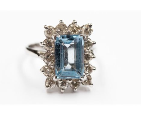 A Blue Topaz and diamond rectangular cluster 18ct white gold ring, the step cut Topaz approximately 11.6 mm by 7.7 mm, fourte