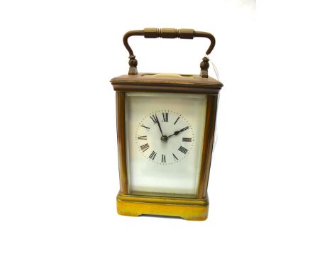 A French brass carriage clock, c. 1900, corniche case, white enamel dial with Roman numerals, visible escapement, the movemen