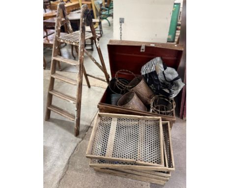 A tin trunk, assorted metal buckets, pine vegetable trays and stepladders