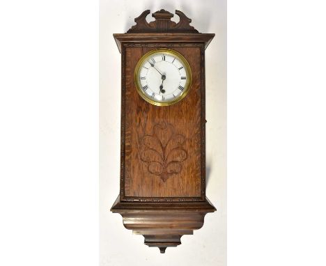 An early 20th century oak cased spring-driven wall clock, the white enamelled dial set with Roman numerals, height 71cm.