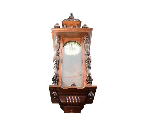A Vienna wall clock in a mahogany case, with arched pediment, the dial with ivorine chapter ring set with Roman numerals, emb