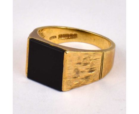 A 9ct gold black onyx signet ring, with textured shoulders, size V, approx. 7.7g.