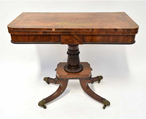 A William IV mahogany fold-over tea table, cross banded and on a carved column, quadripartite oustswept base, 75 x 91 x 48cm.