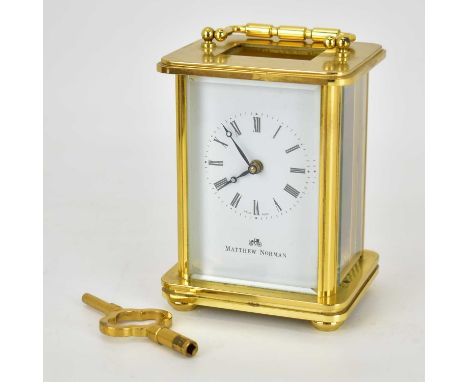 MATTHEW NORMAN; a 20th century brass cased carriage clock with bevelled edge glass panels and swing handle, in presentation c