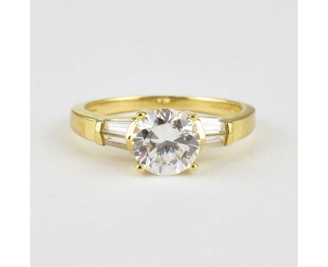 A 14ct gold dress ring with claw set central cubic zirconium flanked by two baguette cut white stones to the shoulders, size 