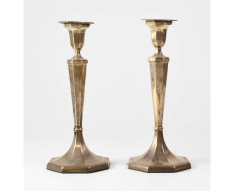 HARRISON BROS &amp; HOWSON; a pair of George V hallmarked silver candlesticks with octagonal tapered columns, on octagonal be