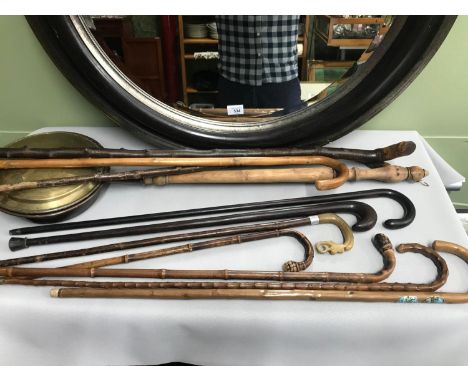 A Collection of various walking sticks which includes two ebony walking sticks &amp; bamboo walking canes, Also in the lot is