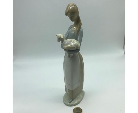 Lladro lady holding a lamb figurine, Measures 26.5cm in height 