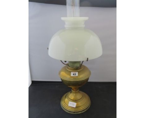 A brass oil lamp with opaque glass shade 