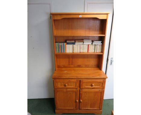 A pine two shelf dresser, the base fitted two cupboard doors enclosing a long shelf and with two drawers above 