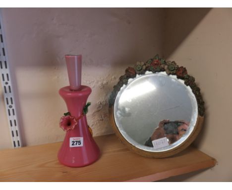 A circular toilet mirror with floral decoration together with a pink glass lamp base 