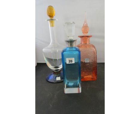 A French La Rochere decanter with yellow stopper and blue foot; a similar orange bubble glass decanter and another with white