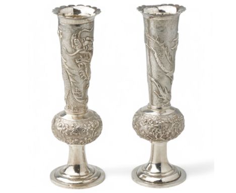 Pair of Chinese export silver spill vases with crimped rims and a raised pattern of dragons, the baluster stems with trailing