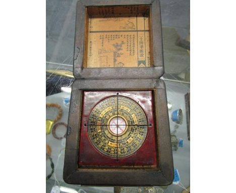 A contemporary Chinese brass and lacquered compass and gilded wooden box, lid set with a brass coin 