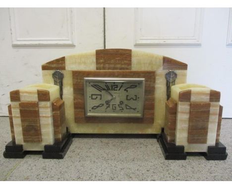 An Art Deco marble mantle clock with two matching garniture, the rectangular dial marked Paul Aubois, Montlucon and having Ar