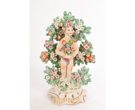A Bow figure of a cherub with flower basket before bocage and a smaller pair of cherubs with baskets of fruit and flowers, da