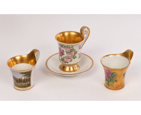 A Berlin topographical cup and saucer and two Berlin cabinet cups, circa 1830-40, the former painted with a detailed view tit