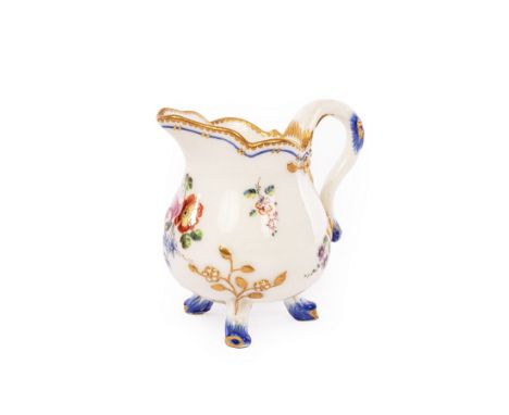 A Sèvres cream jug (pot a lait a trois pieds), circa 1760, of the smallest size, on three stump feet with embossed gold bloss