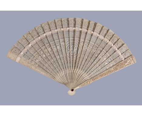 Ω A Chinese ivory brise fan, Canton, circa 1800, each pierced stick intricately carved, with central monogram flanked by band