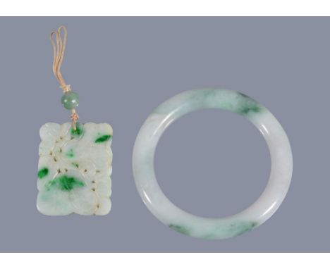  A Chinese jadeite bangle,   with green inclusions, the bangle 8.2cm diameter and inner diameter 6cm and a similar   carved p