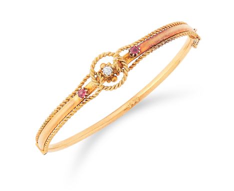 RUBY AND DIAMOND BANGLE set with two round cut rubies and a diamond in twisted gold motif, 6cm inner diameter, 6.7g.