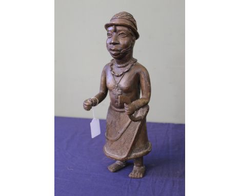 A 20th Century African 'Benin' style cast model, depicting a bare chested male holding a staff and wearing a cross, height 41